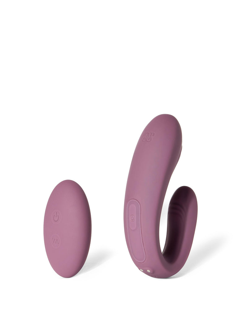 Arcus mauve curved vibrator beside its wireless remote control.